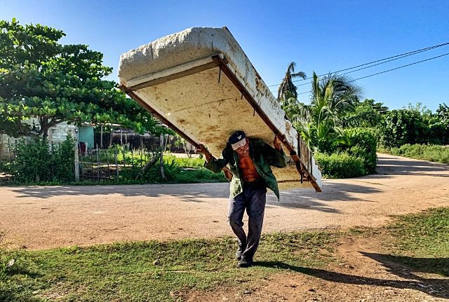 Un hombre carga una balsa improvisada