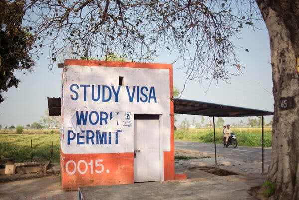 A small building has the words “study visa” and “work permit” painted on it. 