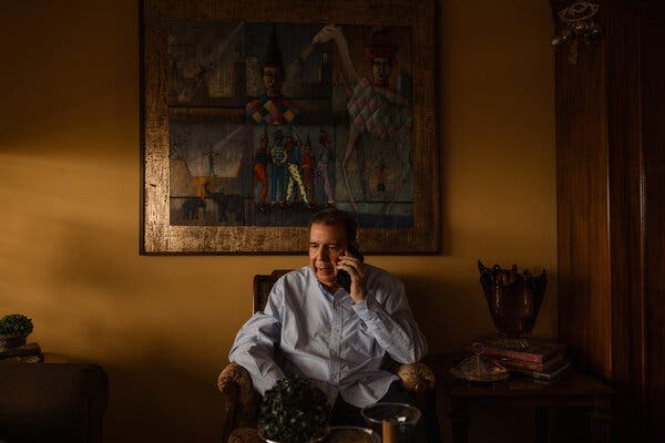 Edmundo González, the leading opposition presidential candidate, speaks on the phone in a dimly lit room.