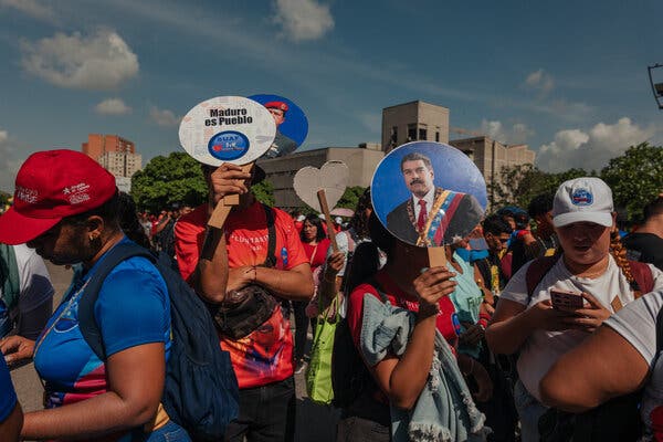 People at a rally with one person holding a photo of Venezuelan President Nicolás Maduro.